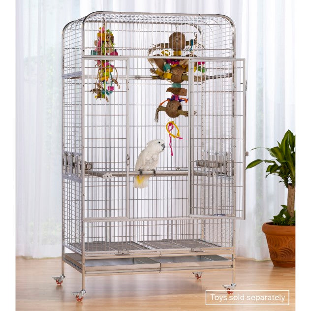 Large bird cage with toys on a wooden floor and white curtain background